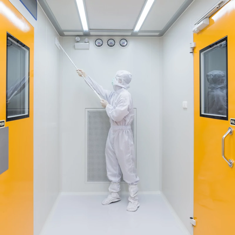 Reinraumreinigung Reinraumreinigung, Mitarbeiterin im sterilen Overall reinigt Übergang im Produktionstrakt