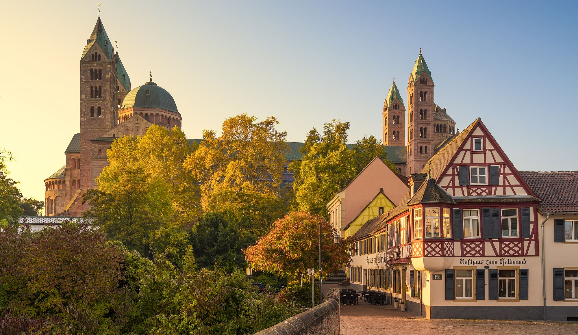 Dom zu Speyer hinter herbstlichen Bäumen, Blick von der Altstadt, im Vordergrund ein Fachwerk-Gasthaus